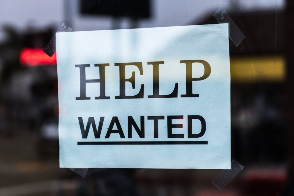 A help wanted sign on display in the window. 