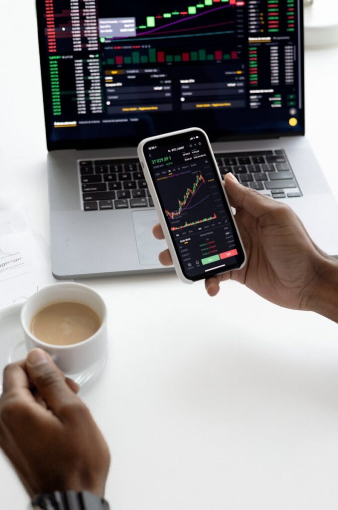 Stock market metrics displayed on a smartphone and laptop. 