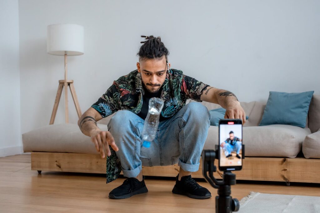 A man filming himself using a smartphone on a tripod. 