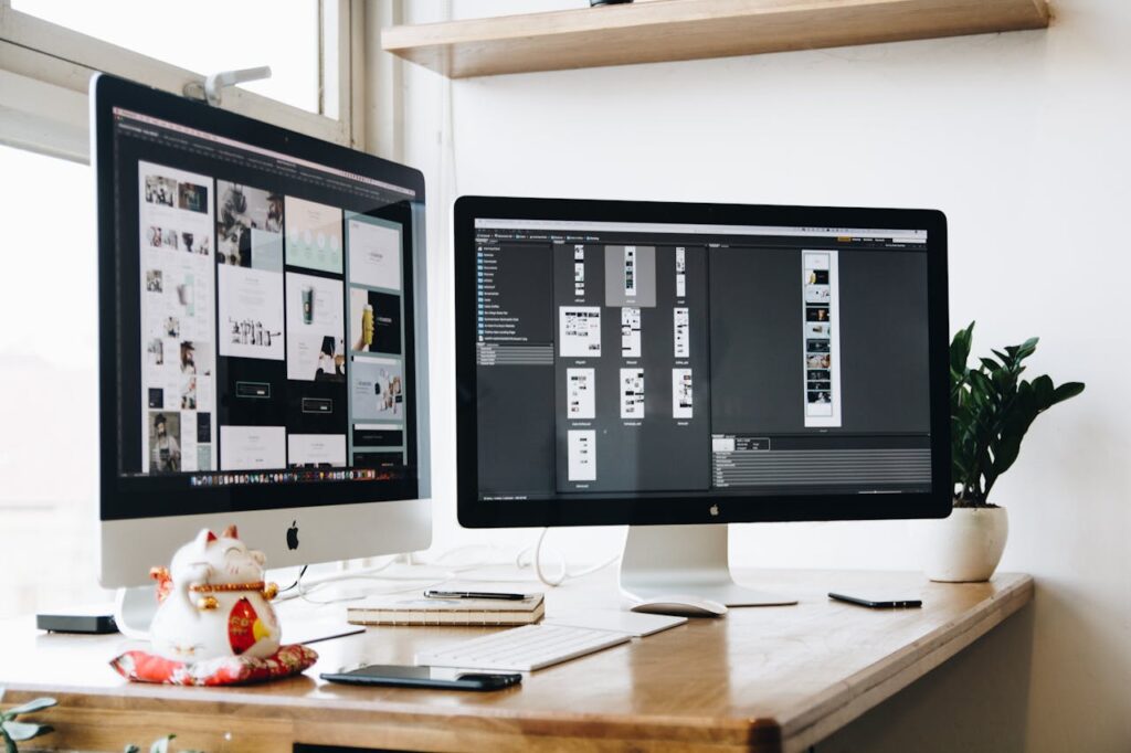 A pair of computer monitors displaying design work.